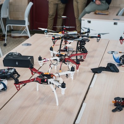 En la imagen se pueden ver varios drones y controles dispuestos sobre una mesa.