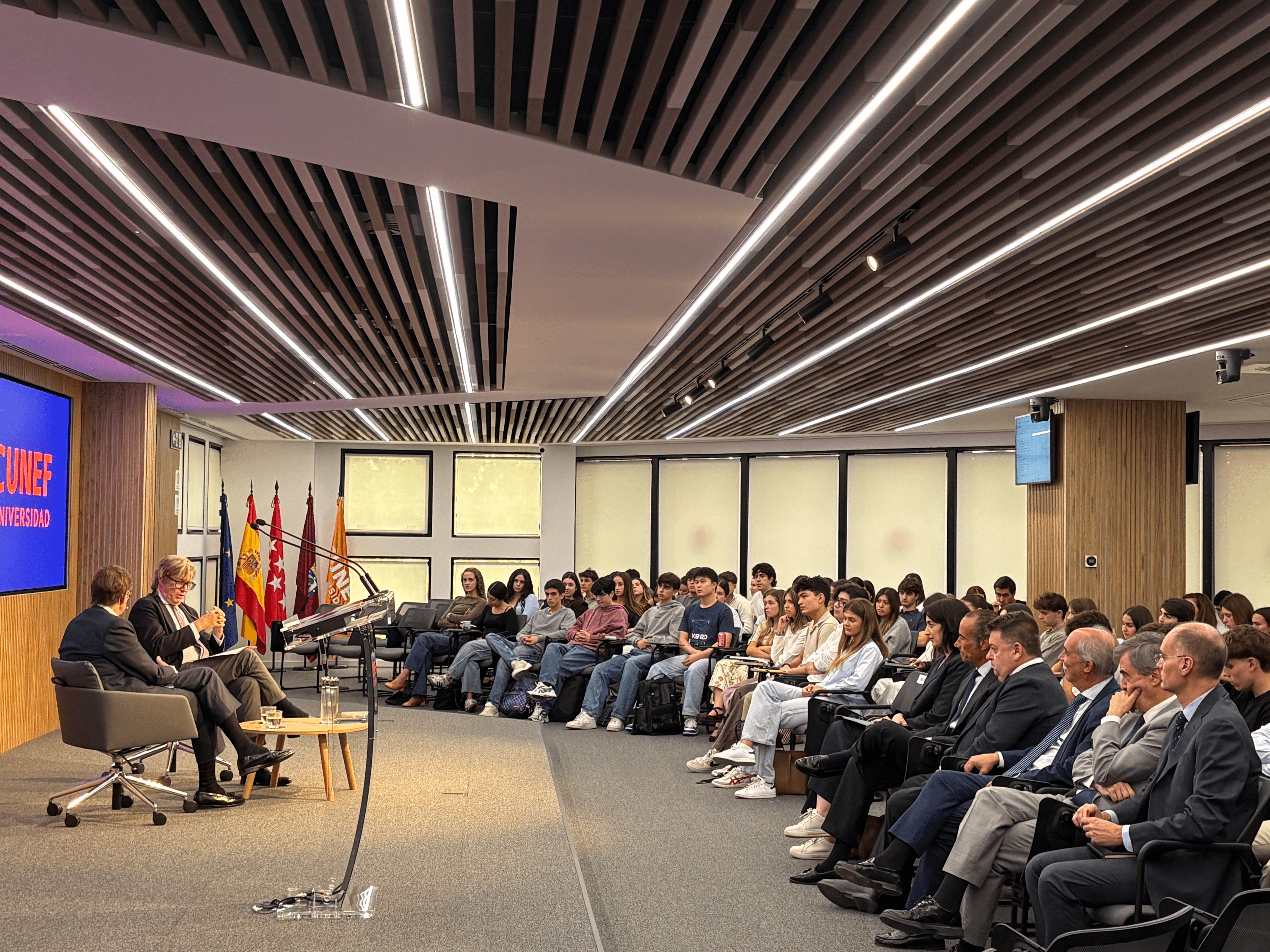 Un grupo de personas sentadas en un auditorio durante un evento o conferencia.